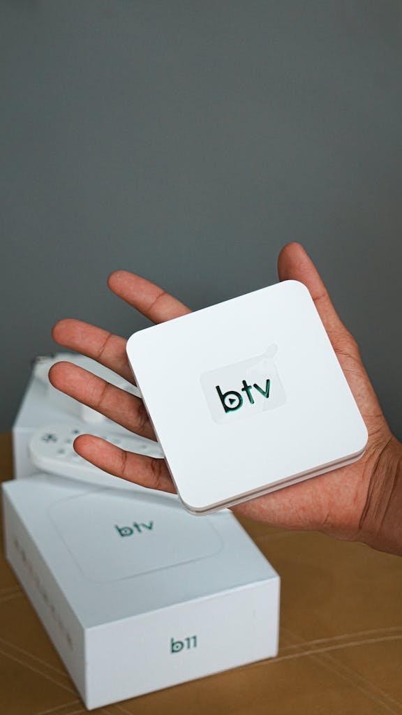 Close-up of a person's hand holding a modern btv digital box.